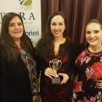 Three Terra employees holding an award.