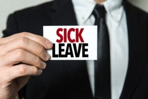 Man holding sign that says "Sick leave"
