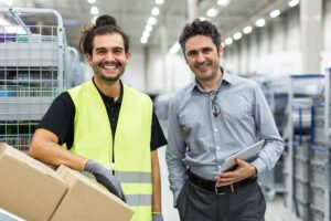 Two smiling employees in a warehouse