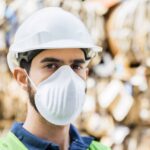 Male worker in mask at recycling center