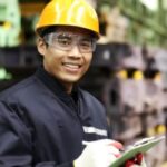 image of worker in manufacturing management role holding clip board