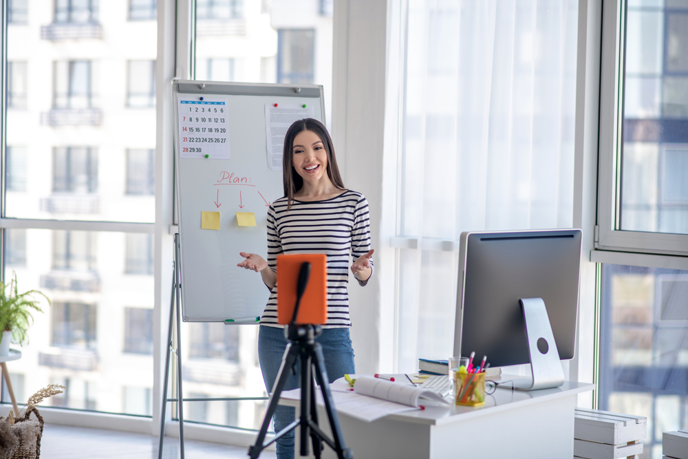 Woman giving presentation to tablet on a tripod. 